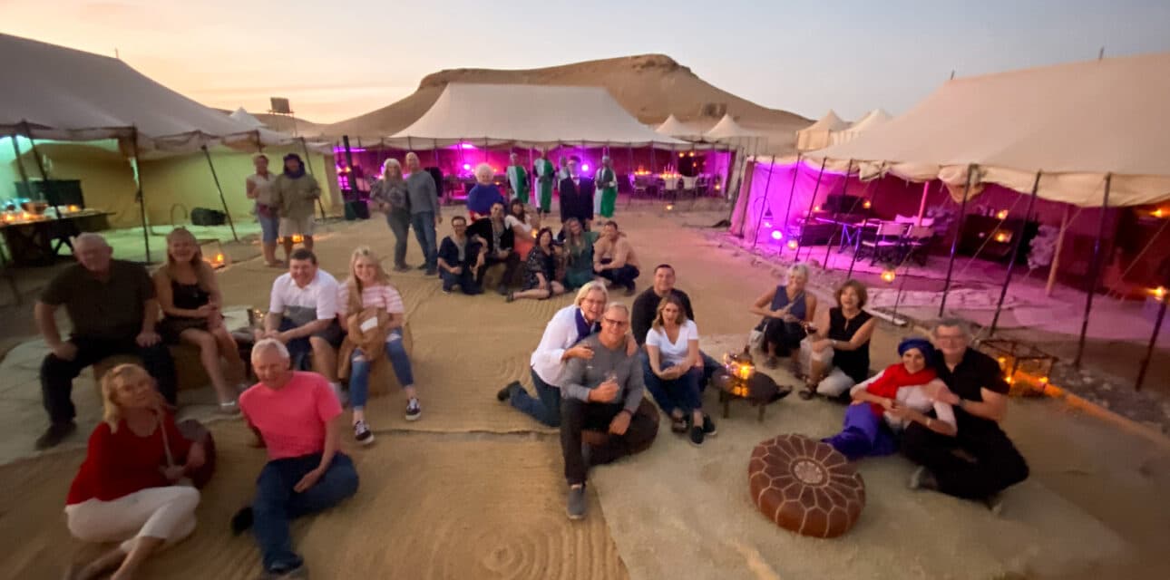 A group oof people at a desert encampment.