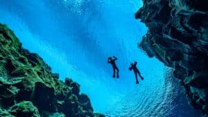 An underwater view of two people swimming.