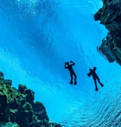 An underwater view of two people swimming.