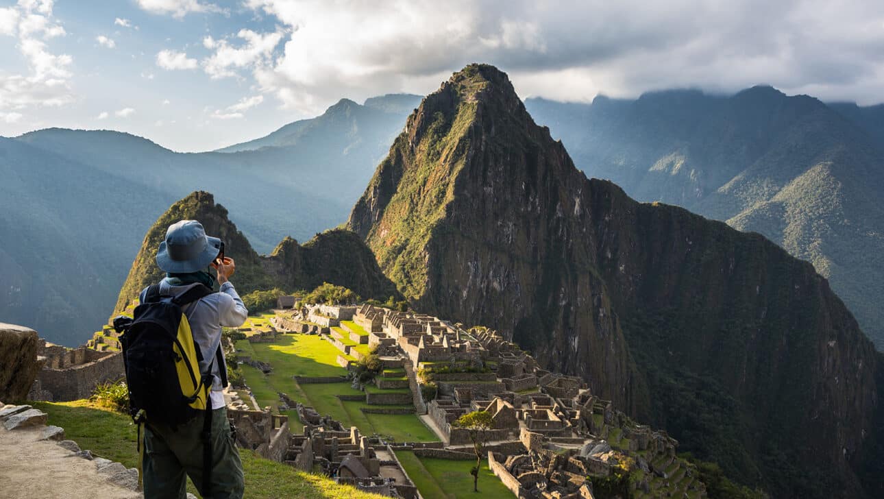 Hiker looking down on Machu Picchu from above the ruins