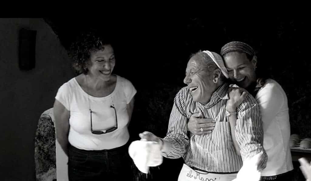 Woman hugs chef in Amalfi making pizza