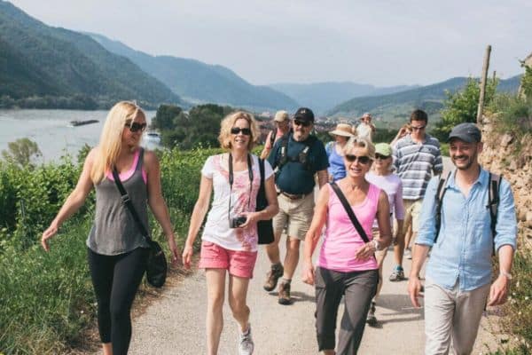 Group walking together along a river and smiling