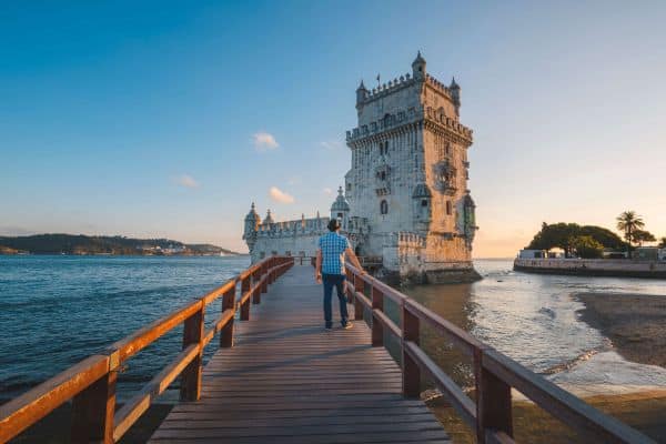 Man walking on a bridge near the water of Lisbon, Portugal