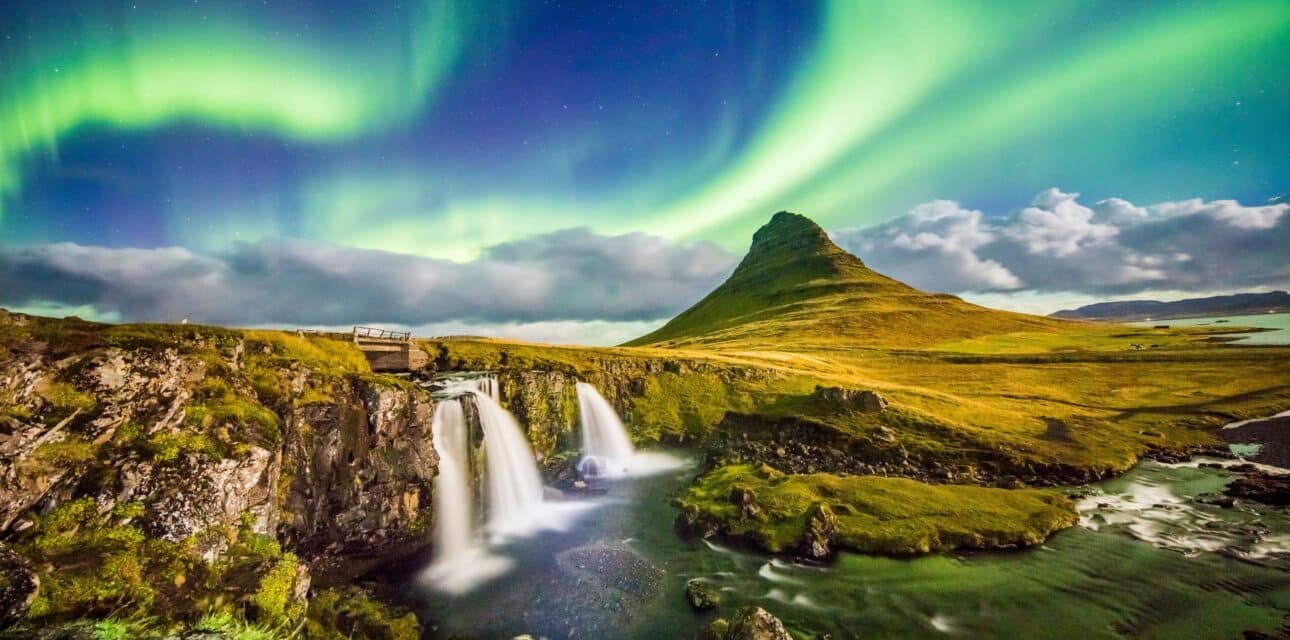 Beautiful Iceland waterfall and volcano landscape with the Aurora Borealis in the background