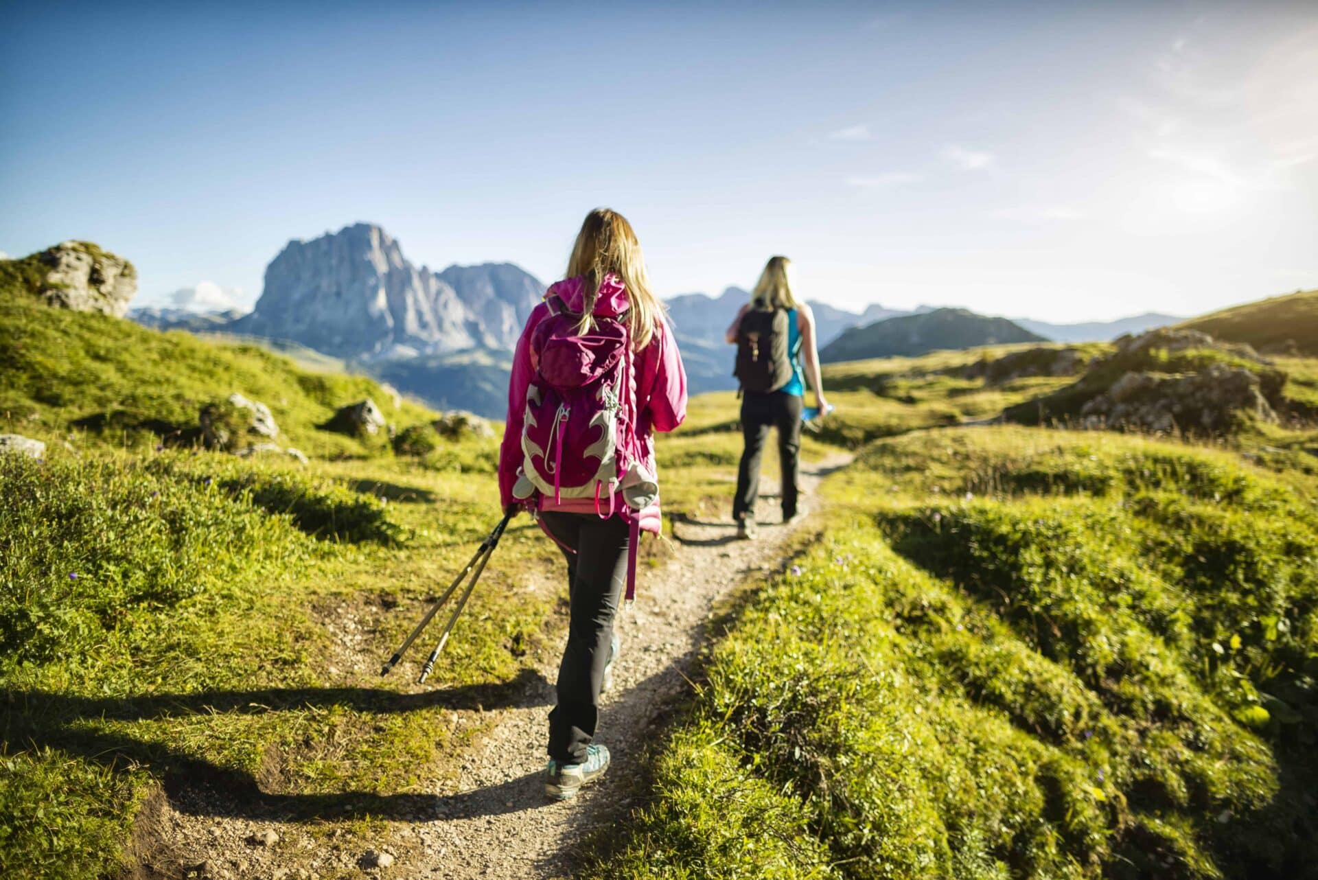 Two female hikers walking on footpath, Dolomites, Italy