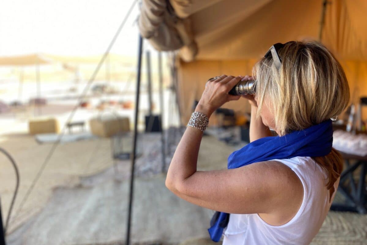 Woman in Morocco using binoculars to look out into the desert