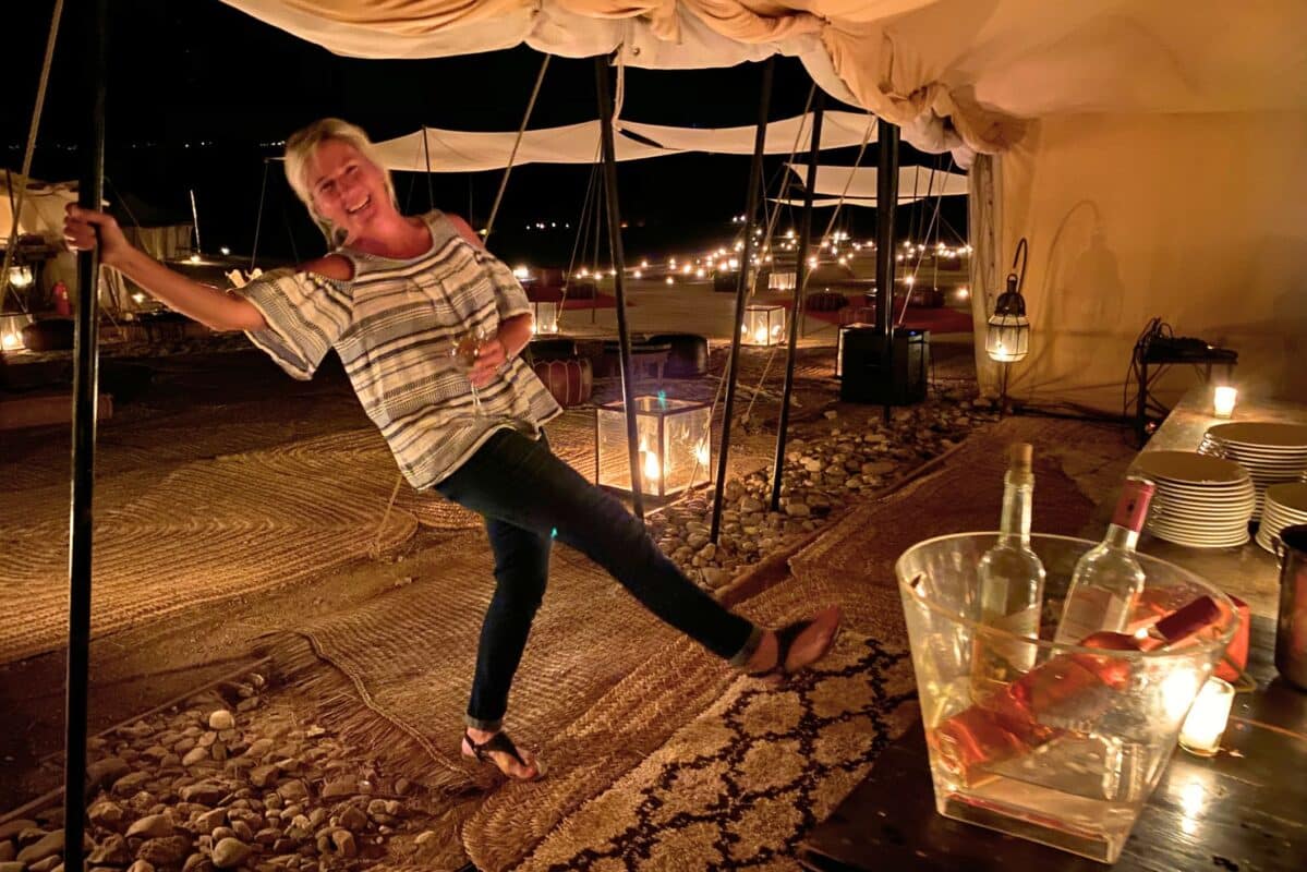 Woman enjoys a glass of wine at a luxury desert encampment in Morocco