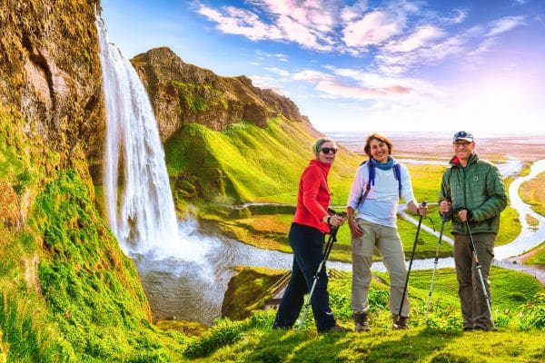 Group of travelers in Iceland by a waterfall